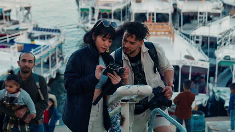 Foreign-tourists-asking-directions-on-the-phone-at-a-boat-pier-on-Nile-river-in-Nubian-village,-Aswan,-Egypt