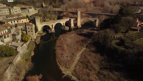 Stadt-Besalu-In-Girona,-Spanien-Mit-Einer-Mittelalterlichen-Brücke-über-Einen-Fluss-Tagsüber,-Luftaufnahme