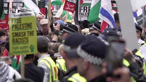 Metropolitan-police-officers-wearing-blue-caps-form-a-security-cordon-line-in-between-two-opposing-groups-of-protestors-during-a-major-public-order-incident