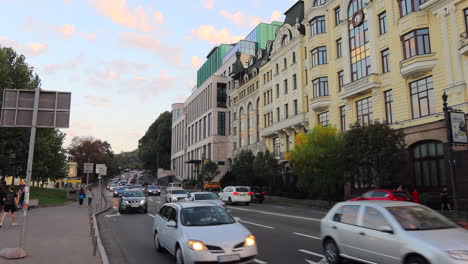 Road-with-cars-driving-and-buildings-in-Kyiv-city-Ukraine,-people-walking,-4K-shot