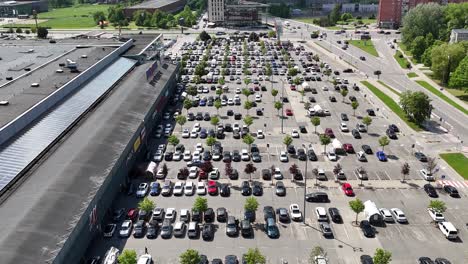 A-busy-shopping-center-parking-lot-on-a-sunny-day,-aerial-view