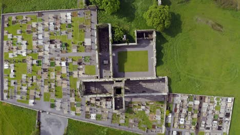 Claregalway-Friary-monastery-ruins-and-cemetery,-drone-high-angle-top-down-ascend