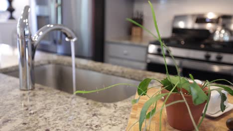 Tight-shot-of-faucet-running-in-kitchen