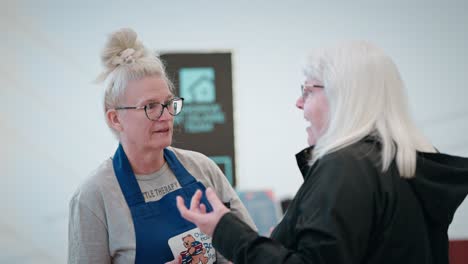 Two-White-Haired-Women-Talking-at-Childrens-Hospital-Book-Market