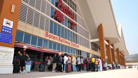 People-queuing-outside-Boten-Railway-Station-in-Laos,-depicting-efficient-travel-and-cross-border-transportation,-highlighting-connectivity-and-movement-within-Southeast-Asia