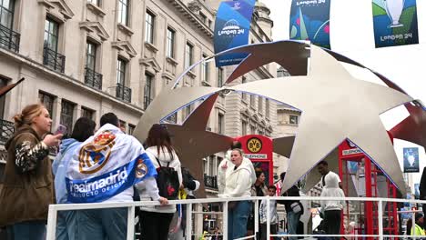 Fan-going-to-see-the-trophy-in-Regents-Street-before-the-UEFA-Champions-League-in-Wembley,-London,-United-Kingdom