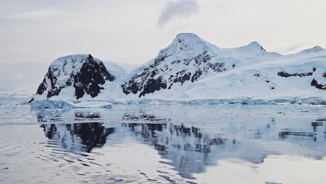 Montañas-Invernales-Al-Atardecer-En-La-Antártida-Y-Océano-Con-Nubes-Y-Cielo-Dramáticos,-Paisajes-Asombrosos-En-La-Costa-De-La-Península-Antártica,-Paisajes-Costeros-Al-Atardecer-En-Una-Escena-Helada-Y-Nevada-En-Clima-Frío