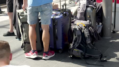 People-waiting-for-their-train-with-their-luggage-and-suitcases-at-Berlin-Central-Station-Medium-Shot