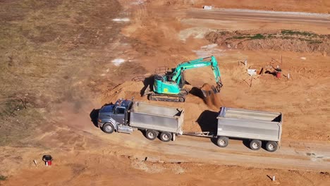 Raupenbagger-Belädt-Einen-LKW-Und-Anhänger