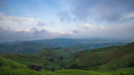 Panyaweuyan,-Landwirtschaftliche-Terrassen-Mit-Vulkanischem-Hang,-Zeitraffer-Der-Morgenwolken,-Die-über-Die-Landschaft-Ziehen,-Indonesien