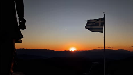 Monument-Zagorian-Women-Pindos-with-Greek-Flag-Fluttering-in-Wind-on-Sunset