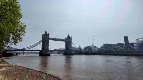 Amplio-ángulo-De-Visión-Del-Tower-Bridge-Que-Se-Alza-Firmemente-Sobre-El-Río-Támesis-Durante-El-Día-En-Londres,-Inglaterra