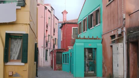 Colorful-narrow-street-with-vibrant-houses-on-Burano-Island,-Venice,-Italy