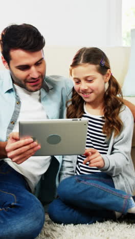 Father-and-daughter-using-digital-tablet-in-living-room