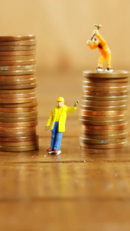 Close-up-of-figurine-with-stack-of-coins