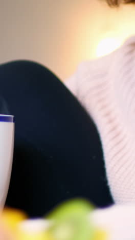 Woman-using-mobile-phone-while-having-coffee