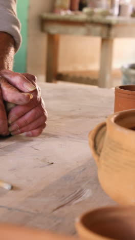 Mid-section-of-female-potter-molding-a-clay