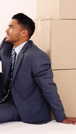 Businessman-leaning-on-cardboard-boxes