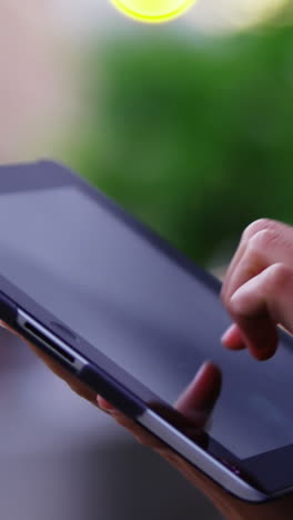 Businesswoman-using-digital-tablet-while-standing-on-street