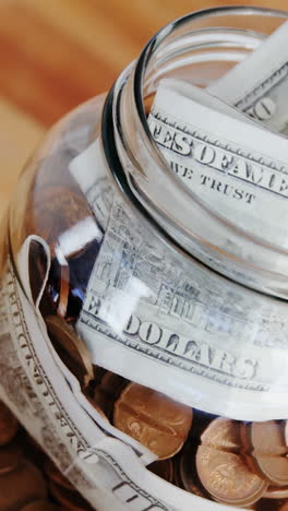 Close-up-of-coins-and-currency-notes-in-bottle