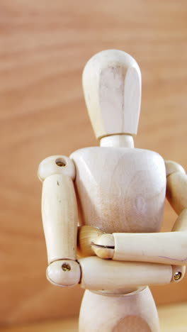 Figurine-standing-with-arms-crossed-on-a-wooden-floor