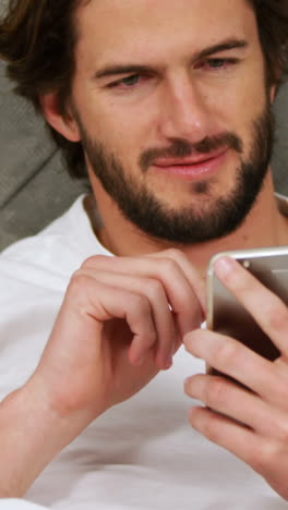 Man-using-mobile-phone-in-bedroom