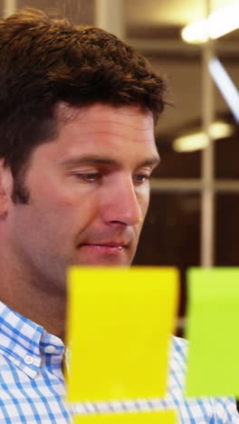 Male-business-executive-looking-at-sticky-notes