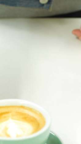 Mid-section-of-man-preparing-cup-of-coffee-in-kitchen