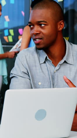 Business-executives-discussing-over-laptop