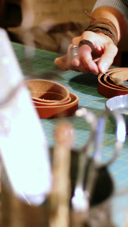 Mid-section-of-craftswoman-preparing-leather-belt