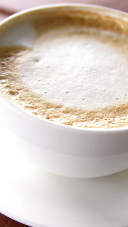 Cup-of-coffee-with-saucer-and-spoon-on-table