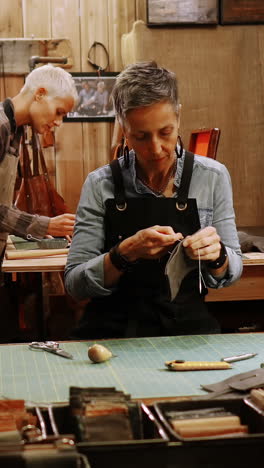 Craftswoman-stitching-a-piece-of-leather