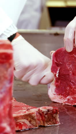 Mid-section-of-butcher-slicing-meat