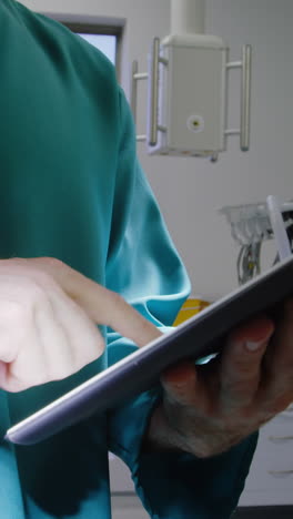 Surgeon-using-digital-tablet-in-operation-room