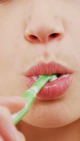 Portrait-of-woman-brushing-her-teeth-in-bathroom