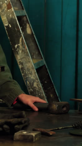 Female-welder-examining-a-piece-of-metal