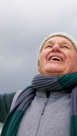 Happy-senior-man-standing-on-the-beach