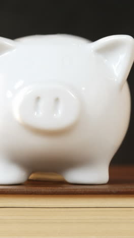 Close-up-of-books-stack-with-piggy-bank