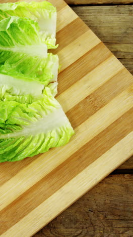 Lettuce-and-tomatoes-in-bowl-on-chopping-board