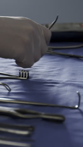 Close-up-of-surgeon-arranging-surgical-tools-on-tray