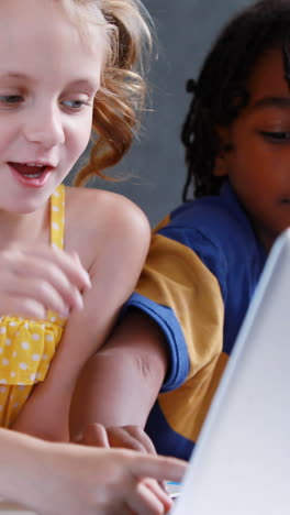 School-kids-using-laptop-in-classroom