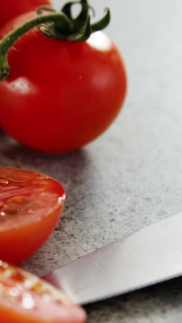 Tomates-Cherry-Y-Cuchillo-De-Cocina-Sobre-Hormigón