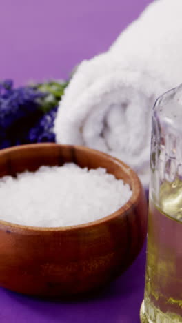 Sea-salt-in-wooden-bowl,-towel,-oil,-candle-and-flowers