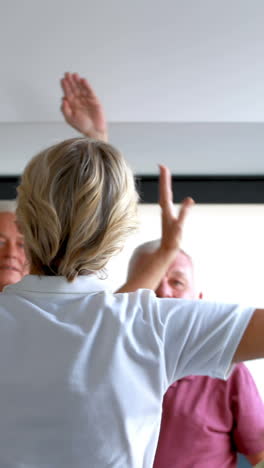 Trainer-assisting-senior-citizens-in-exercising