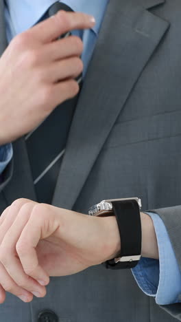 Mid-section-of-businessman-using-smartwatch