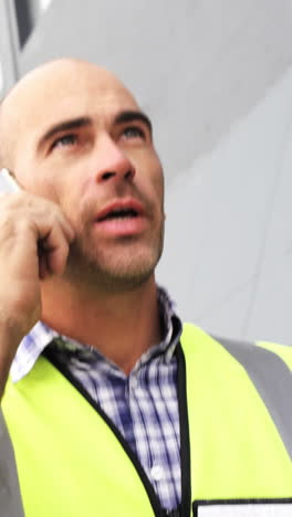 Welder-talking-on-phone-outside-workshop