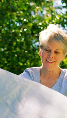 Senior-couple-looking-at-map-in-garden