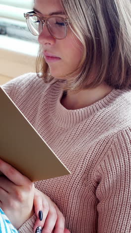 Woman-reading-a-novel-in-living-room