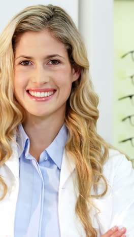 Beautiful-optometrist-standing-with-arms-crossed-at-ophthalmology-clinic