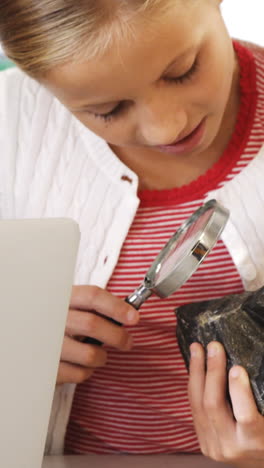 School-kids-using-magnifying-glass-over-rock